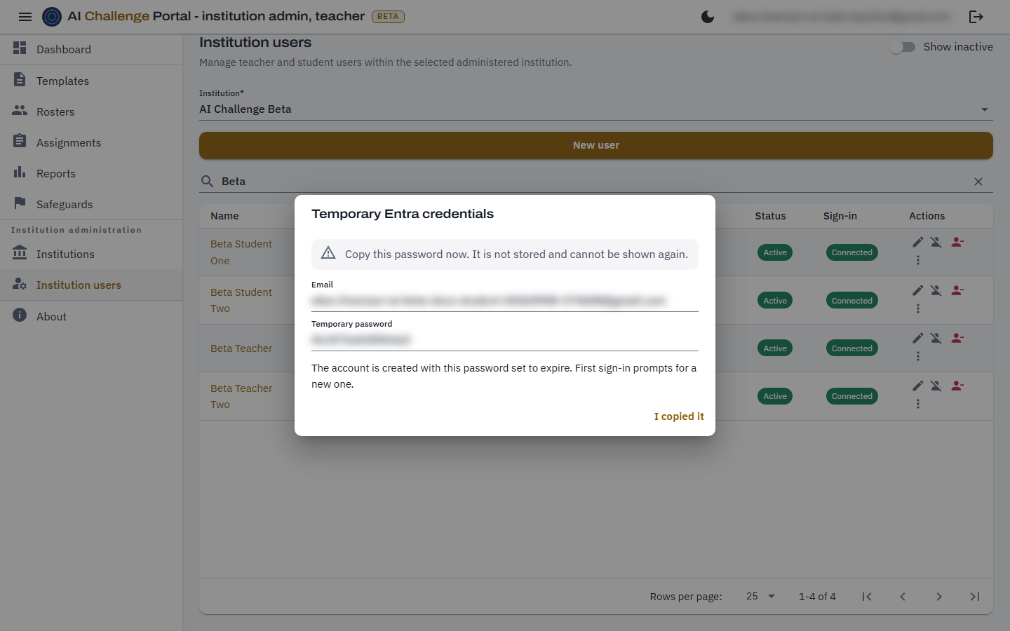 The Temporary Entra credentials dialog, headed by a warning that the password is not stored and cannot be shown again, above a read-only email box and a read-only temporary password box, with an I copied it button beneath. Both the address and the password are blurred.
